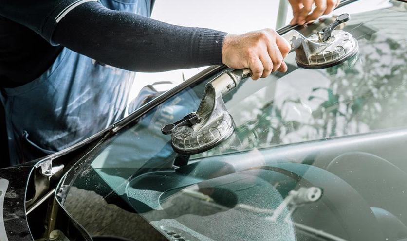 Mechanic replacing car windshield